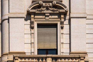 Süslü taş işçiliği ve klasik pencere tasarımı içeren zarif mimari ön cephe.