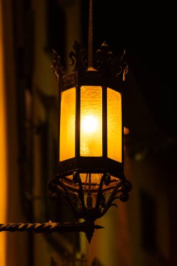 Eski sokak feneri gece aydınlandı ve sıcak bir atmosfer yarattı..