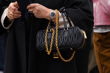 Paris, Fransa - 11 Mart 2025: Siyah dikdörtgen kaplama altın zincirli Miu Miu el çantası. Sokak tarzı kıyafet ayrıntıları.