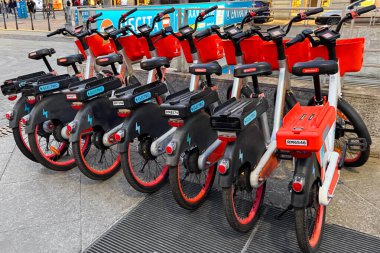 Milan, İtalya - 12 Nisan 2025: Centrale FS yakınlarındaki bisiklet paylaşım istasyonuna park edilmiş elektrik kiralama bisikletleri. Milan toplu taşıma sistemi. Kentsel hareketlilik.