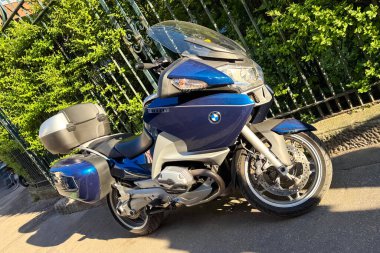 Milan, İtalya - 11 Nisan 2025: BMW R1200RT güneşli caddeye park etti. Mavi ve gümüş renkli, pannier ve üst kutulu bir motosiklet..