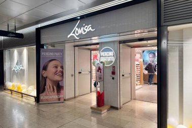 Milan, İtalya - 07 Nisan 2025: Milano 'da Lovisa mücevher dükkanı. Beyaz fayanslı mağaza önü, delen promosyon tabelaları, posterler ve küpe içerisi..