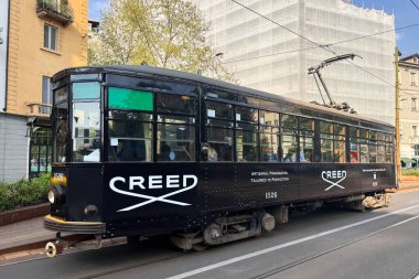 Milan, İtalya - Nisan 08, 2025: BREED parfüm reklamlı siyah tramvay Milan sokaklarında dolaşıyor. Sanatsal parfüm markası, şehir ulaşımı..