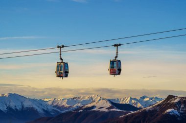 Piani di Bobbio, İtalya - 24.12.2022: Karla kaplı dağların üzerinden geçen iki teleferik, Alp manzarası ve sakin kış manzarası