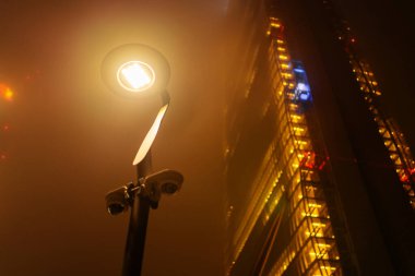 Milan, İtalya - 01.01.2022: Tre Torri Parkı. Sisli bir gece sahnesi. Parlayan sokak lambası ve aydınlık gökyüzü..