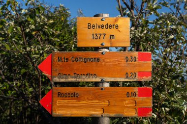 Belveder, İtalya - 10.09.2022: İtalya 'nın Valsassina kenti Piani Resinelli' de Belvedere del Parco Valentino yakınlarındaki çeşitli dağlık noktaların yönlerini gösteren tahta tabelalar