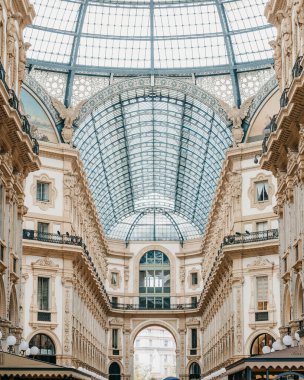 Milan, İtalya - 31.08.2022: Galleria Vittorio Emanuele II. Tarihi alışveriş galerisinde zarif mimari ve cam tavan.