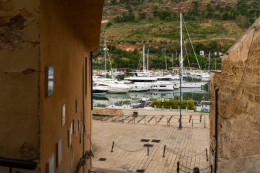 Castellammare del Golfo, İtalya - 05.11.2022: Resimli liman manzaralı yatlar antik kıyı köyüne kenetlendi.