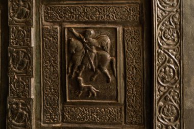 Monreale, İtalya - 04.11.2022: Ortaçağ şövalye sahnesi tarihi kapının üzerine karmaşık şekiller oyulmuş.