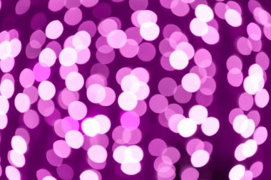Soyut mor Bokeh ışıkları karanlık arka planda sıcak ve şenlikli atmosfer yaratır. Kutlamalar ya da tatiller için mükemmeldir.