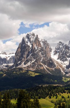 İtalya 'nın Dolomites kentindeki Funes Vadisi yakınlarındaki kar ve çam ormanlarıyla dağların görkemli zirvesi.