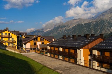 Passo Tonale, İtalya - 10.08.2024: Huzurlu manzaralı renkli evlerle manzaralı dağ köyü sahnesi.
