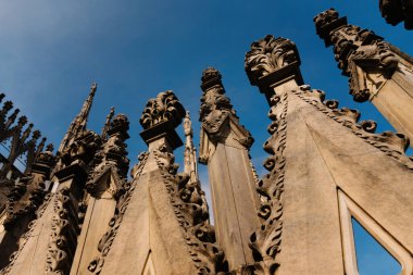 Milan, İtalya - 19.03.2024: Gotik mimari detaylar ikonik katedral Milan Duomo Katedrali 'nde mavi gökyüzüne karşı.