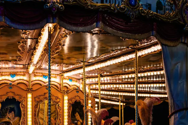 Gece, süslü detaylar ve sıcak ışıklarla aydınlatılmış atlıkarınca..