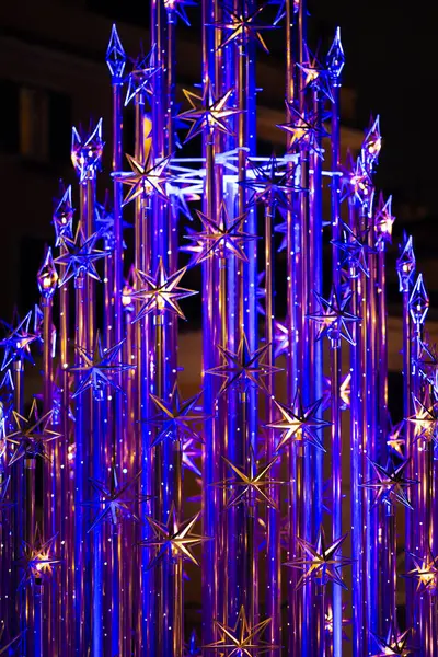 Roma, İtalya - 09.12.2022: Yıldız şekilli mor ve mavi ışık heykellerinin canlı gece gösterisi.