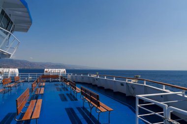 Sicilya, İtalya - 27.07.2024: Temiz gökyüzünün altında açık koltuklu sakin feribot yolculuğu.