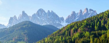 İtalya 'nın Dolomites kentindeki Funes Vadisi yakınlarında gün ışığında ormanlı görkemli bir dağ sırası.