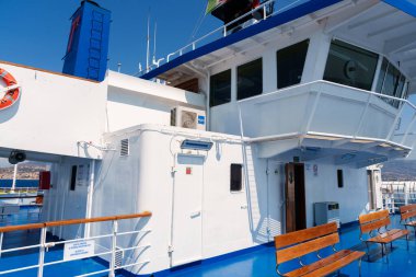 Sicilya, İtalya - 27.07.2024: Rahatlamak için ahşap banklarla yolcu feribot güvertesinde güneşli deniz macerası.