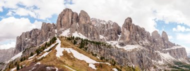 İtalya 'nın Dolomites kentindeki Funes Vadisi yakınlarında kar yamaçları ve dramatik gökyüzü manzaralı görkemli bir dağ sırası..