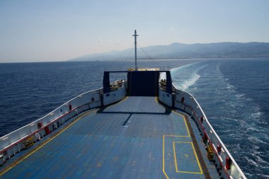 Sicilya, İtalya - 27.07.2024: Açık deniz yolculuğundaki feribot güvertesinden açık gökyüzü altındaki uzak dağlarla manzara.