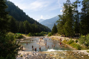 Passo Tonale, İtalya - 10.08.2024: Resimli dağ nehir manzarasında yaz tatili.