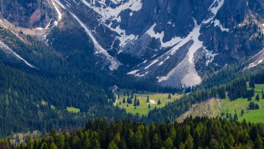 İtalya 'nın Dolomites kentindeki Funes Vadisi yakınlarındaki çam ormanlı görkemli karlı dağlar..