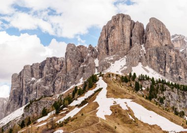İtalya 'nın Dolomites kentindeki Funes Vadisi yakınlarındaki mavi gökyüzünün altında kar yamaçları ve kayalık tepeleri olan manzaralı dağ manzarası..