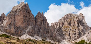 İtalya, Dolomitler 'deki Funes Vadisi yakınlarında kayalık tepeleri ve mavi gökyüzü olan görkemli dağ sıraları.