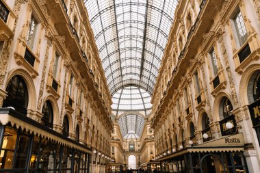 Milan, İtalya - 19.03.2024: Galleria Vittorio Emanuele II. Tarihi alışveriş galerisinde büyük mimari ve çarpıcı cam tavan.