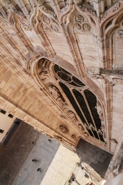 Milan, İtalya - 19.03.2024: Gotik katedral mimarisinin havadan görünüşü ve altında süslü taş ayrıntıları ve şehir manzarası bulunan Milan Duomo Katedrali.