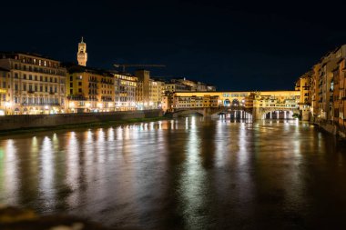 Floransa, İtalya - 31 Ağustos 2022: Arno Nehri üzerindeki aydınlık köprüler ve yansımalarla Floransa şehir manzarası