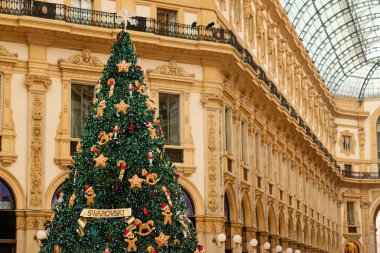 Milan, İtalya - 18.12.2022: Zencefilli ekmek süslemeleri de dahil olmak üzere festival süsleriyle süslenmiş Noel ağacı, Victor Emmanuel 'in galerisinin merkezinde yer alıyor. Lüks tatil atmosferi
