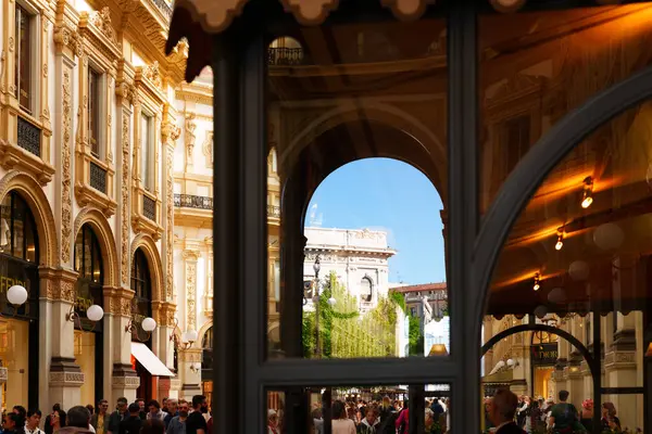 Milan, İtalya - 20.05.2024 Victor Emmanuel Galerisi. Yansıtıcı camdan görülen tarihi mimari ve hareketli kalabalığın görüntüsü