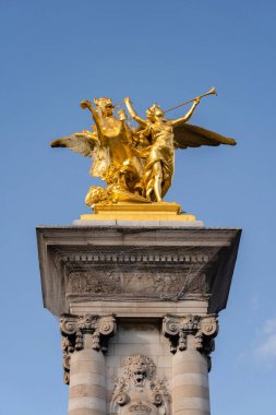 Paris, Fransa - 1 Ekim 2022: Günbatımında Alexandre Köprüsü 'nün sütununda altın heykel