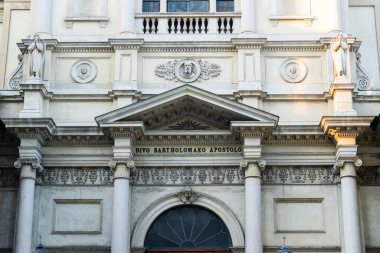 Heykeller, sütunlar ve gün ışığında yakalanan karmaşık oymalar içeren süslemeli kilise cephesi.