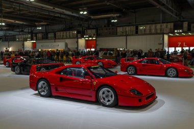 Milan, İtalya - 12.11.2022: Kapalı mekanda coşkulu kalabalık ile klasik kırmızı Ferrari spor arabaları. Milano Otoklasik Sergisi.