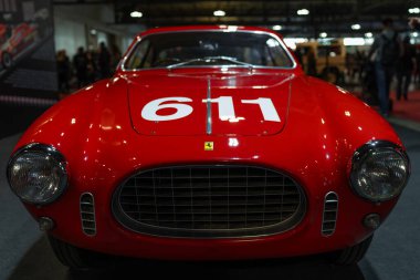 Milan, İtalya - 12.11.2022: Araba fuarında yarış numarası sergilenen klasik kırmızı Ferrari arabası. Milano Otoklasik Sergisi.