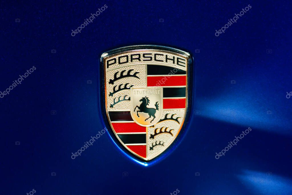 Milan, Italy - 12.11.2022: Close-up of Porsche logo emblem on blue background. Milano Autoclassica exhibition.