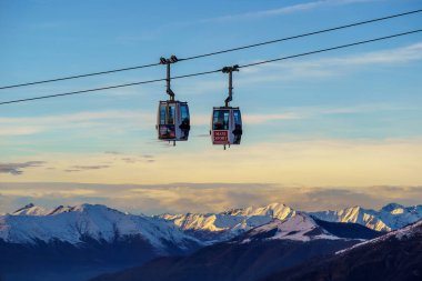 Piani di Bobbio, İtalya - 24.12.2022: Karla kaplı dağların üzerinden geçen iki teleferik, Alp manzarası ve sakin kış manzarası