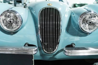 Milan, İtalya - 12.11.2022: Klasik mavi klasik Jaguar XK120 araba ön ızgarası ve otomotiv tasarımı için yakın çekim ışıkları. Milano Otoklasik Sergisi.