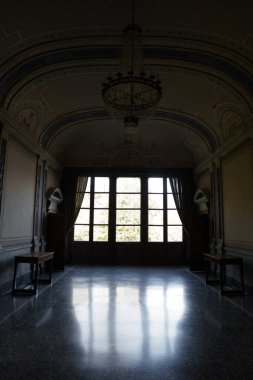 Villa Carlotta, İtalya - 24.03.2024: Como Gölü 'ndeki tarihi villa Carlotta' da az aydınlatılmış oda büyük avize, kemerli tavan ve ayrıntılı duvar süslemeleriyle donatılmış