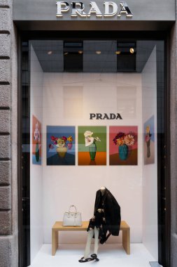 Milan, İtalya - 24.04.2024: Lüks moda Prada vitrininde zarif çiçek sanatı ve tasarımcı aksesuarları sergileniyor.