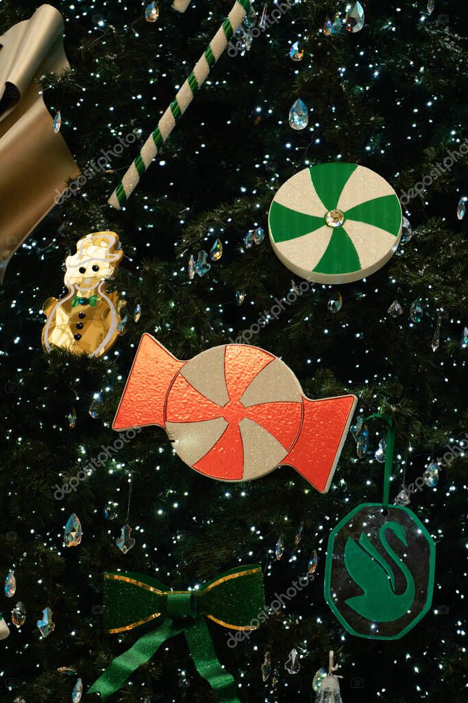 Milan, Italy - December, 23, 2021: Christmas Tree Swarovski 2021 in center of the Galleria Vittorio Emanuele II in front of Swarovski boutique. Closeup.