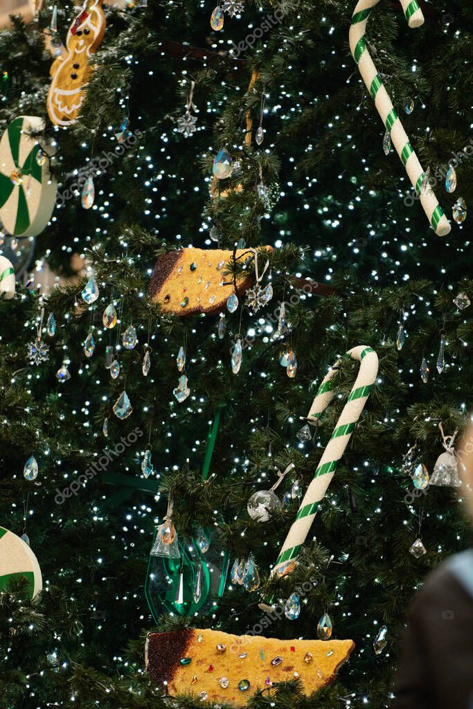 Milan, Italy - December, 23, 2021: Christmas Tree Swarovski 2021 in center of the Galleria Vittorio Emanuele II in front of Swarovski boutique. Closeup.