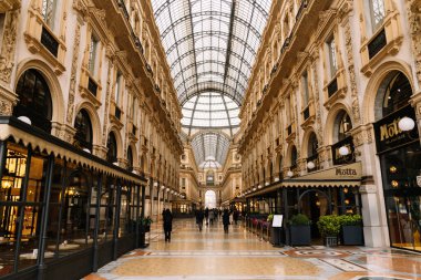 Milan, İtalya - 19.03.2024: Galleria Vittorio Emanuele II. Tarihi mimarisi ve cam kubbesi olan şık bir alışveriş salonu..