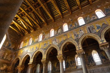 Monreale, İtalya - 25 Temmuz 2024: Katedralin tek katedralli iç mimarisi büyük kemerli sütunlar ve incilsel sahneler tasvir eden karmaşık altın mozaikler