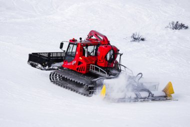 Passo Tonale, İtalya - 28.01.2023: Karlı dağ yamacını temizleyen ve hazırlayan karlı araç, kar hareket ederken kenara itiliyor, alp kayak merkezi