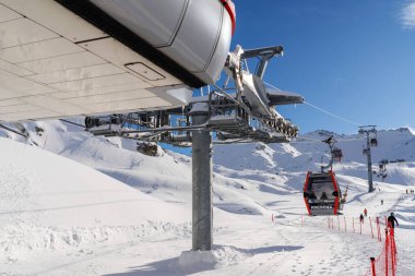 Ponte di Legno, İtalya - 03.12.2023: Karlı dağ manzarasında kayak gondolu, teleferikli ve Alp kayak merkezindeki kayak yamaçlı. Passo Tonale, Presena Buzulu