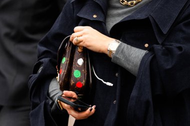 Milan, İtalya - 25 Şubat 2024: Kadın Louis Vuitton marka çanta giyer, moda blogcusu kıyafeti ayrıntıları, sokak tarzı