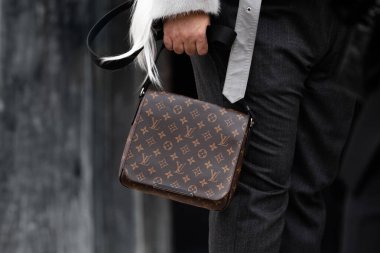 Milan, İtalya - 25 Şubat 2024: Kadın Louis Vuitton marka çanta giyer, moda blogcusu kıyafeti ayrıntıları, sokak tarzı